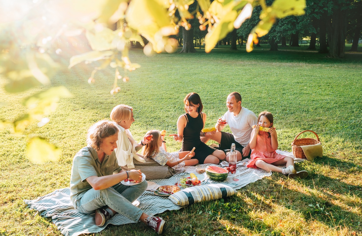 Big family having an outdoor picnic and enjoying fresh food.
