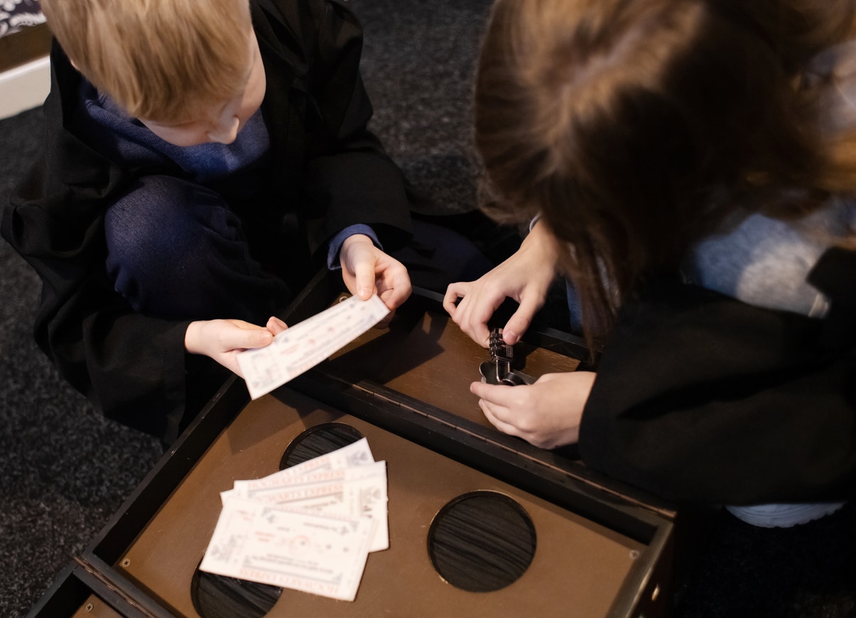 Kids going through tasks and looking for keys to solve the escape room.