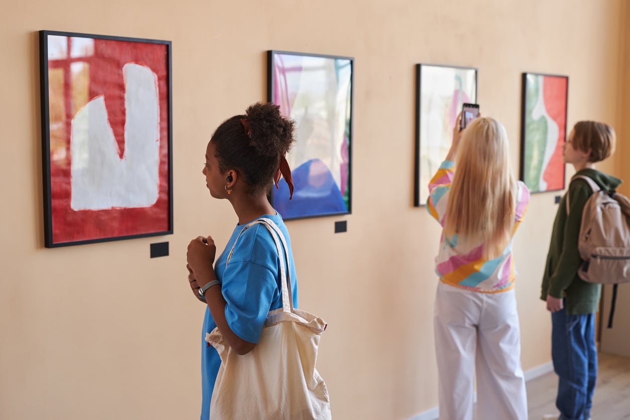 Diverse group of teenagers viewing art in an art museum.
