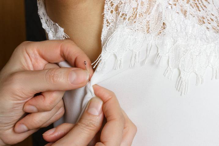 a bride getting her wedding gown altered