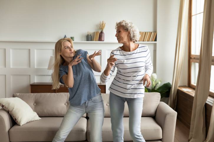 Mother and daughter dancing in the living room