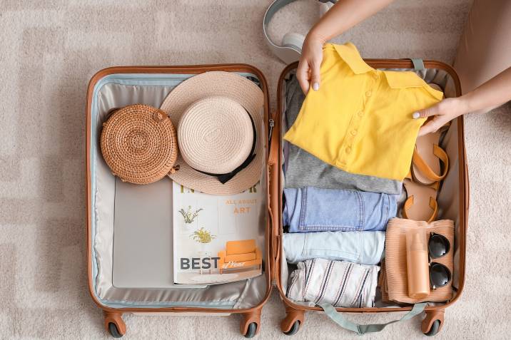 Woman packing suitcase at home