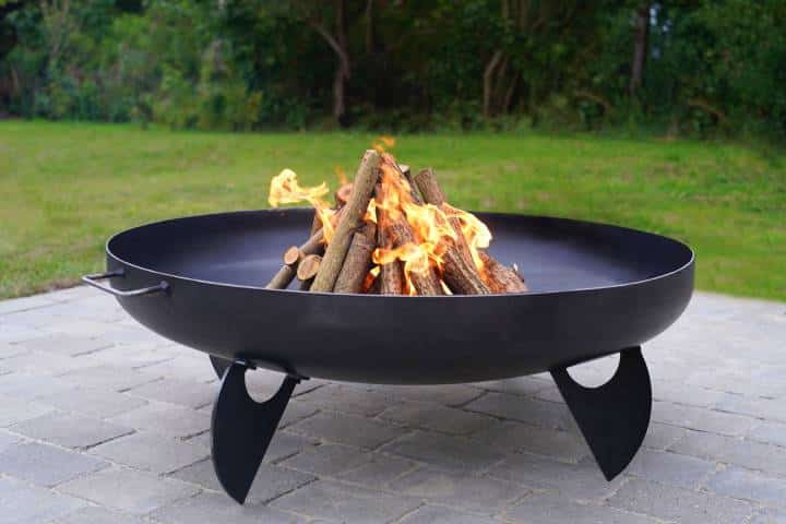 Iron fire pit and burning fire in a garden