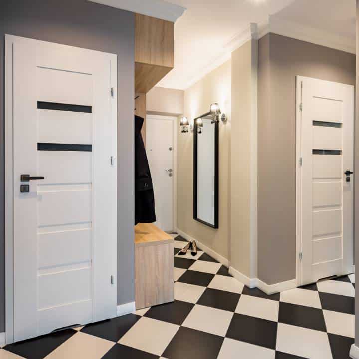 Modern home corridor with chess floor tiles and white doors