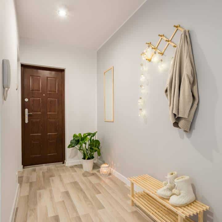 Cozy entryway with wooden floor panels and shoe bench