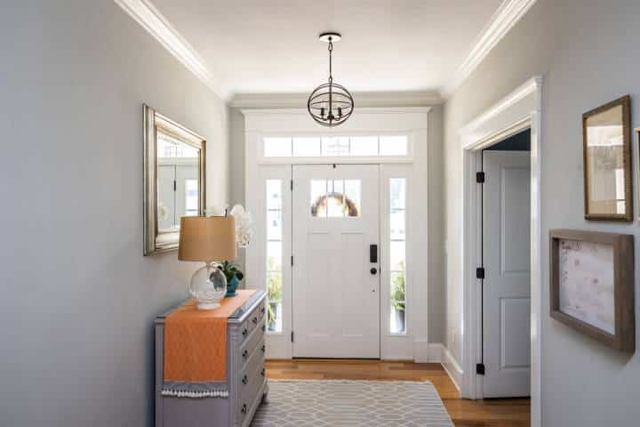 A wide front door hallway foyer with hanging light fixture