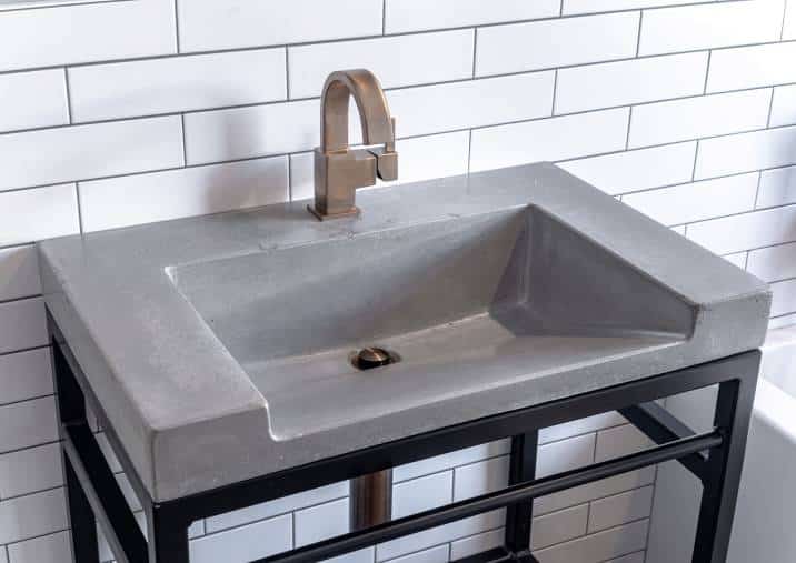 concrete laundry sink with bronze and black fixtures