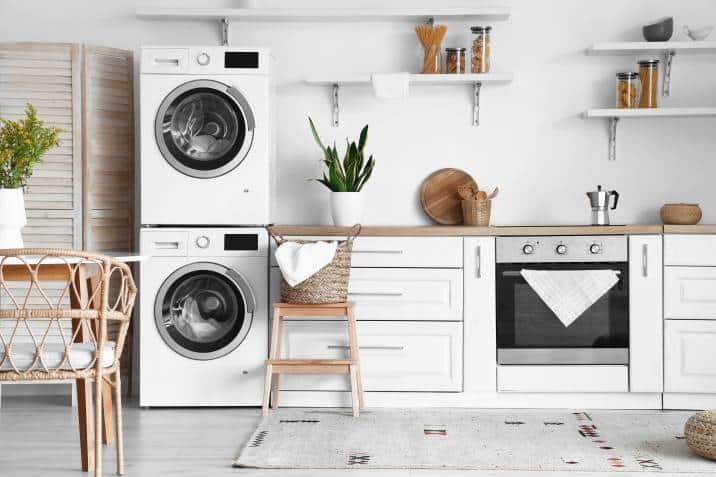 white kitchen with washing machines, white counters and shelves