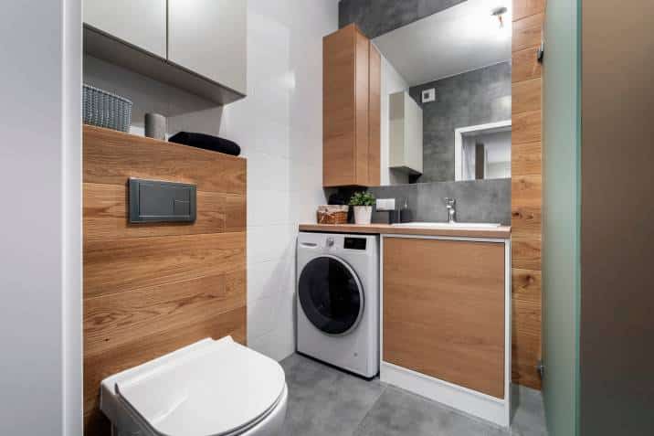 modern bathroom with wooden finishing, with washing machine