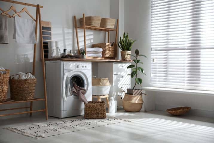 stylish laundry room interior with modern washing machine and window blinds