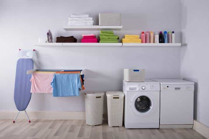 laundry room with retractable drying rack and washing machine, clothes hanging on the rack
