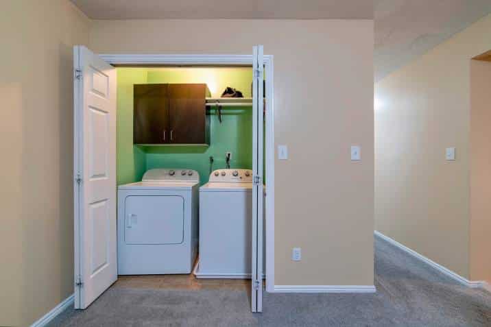 small room with laundry appliances and sliding double doors inside a home