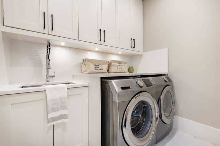 white standalone sink with washer and dryer