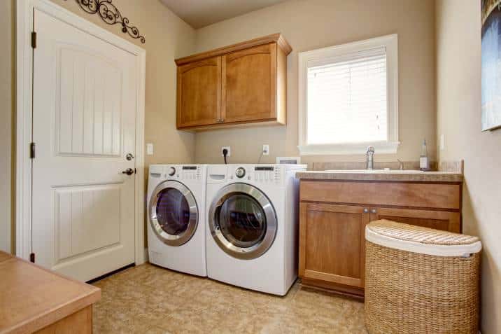 Laundry room with washer and dryer. Wooden cabinets and tile floor