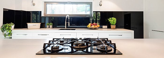 Contemporary minimalist kitchen with white furniture, rectangular window and a gas cooktop in the first ground