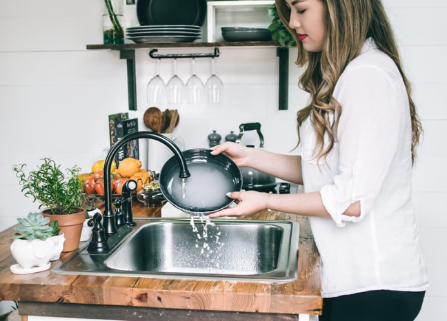 Woman rinsing a plate