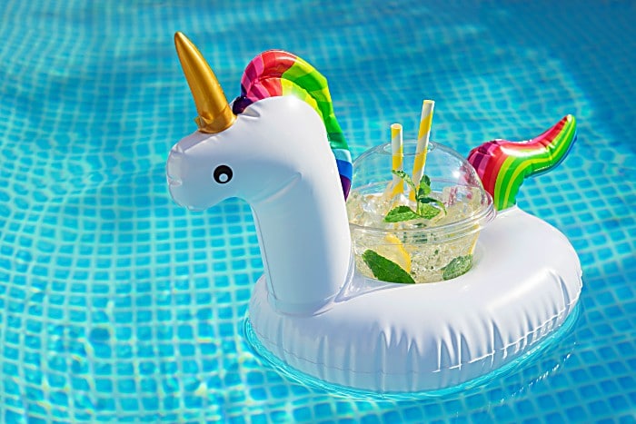 Summer refreshing mojito cocktail in an inflatable stand - unicorn. Original Drink Serving in the pool with water