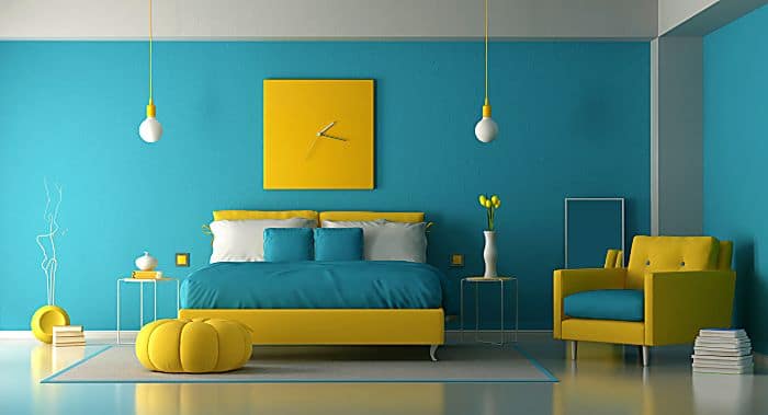 Blue and yellow master bedroom with double bed and armchair 