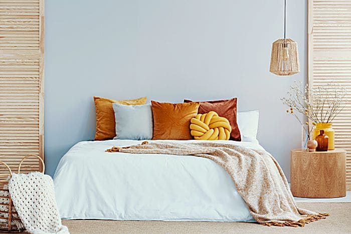 Warm blanket on white duvet in cozy bedroom interior