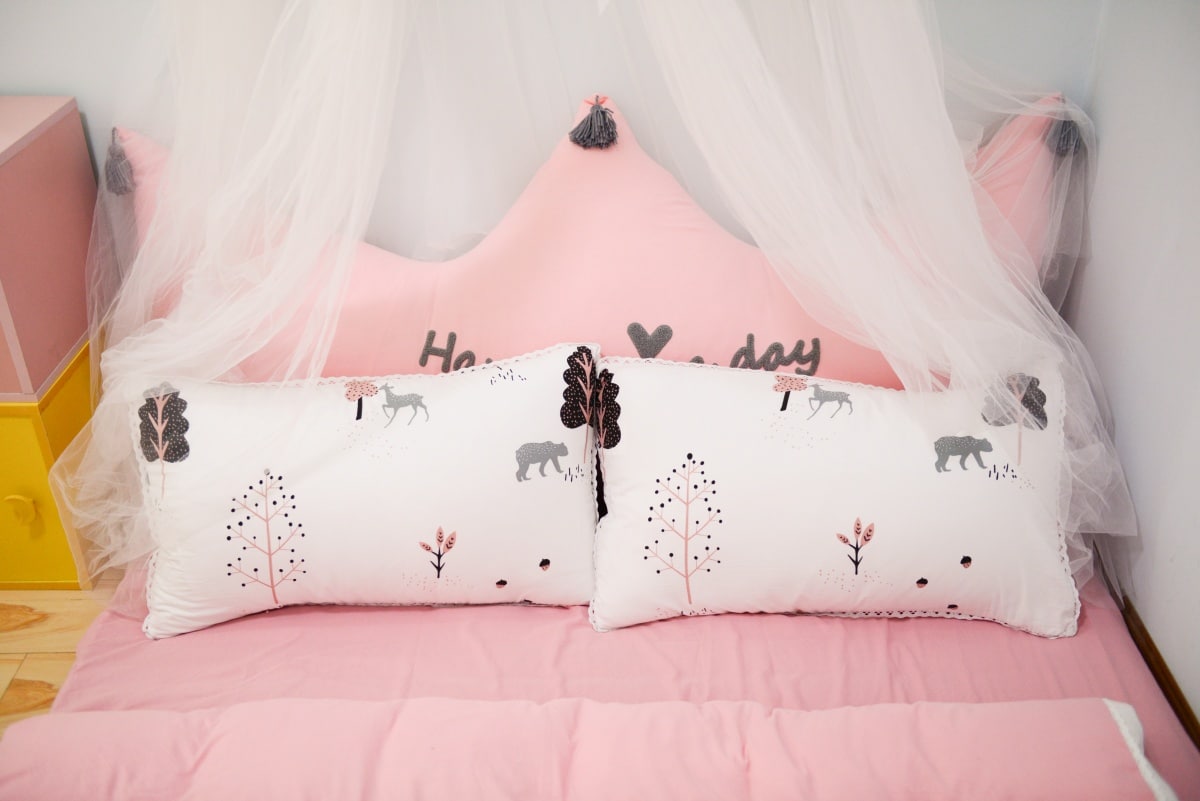 bed with white and pink printed bedding
