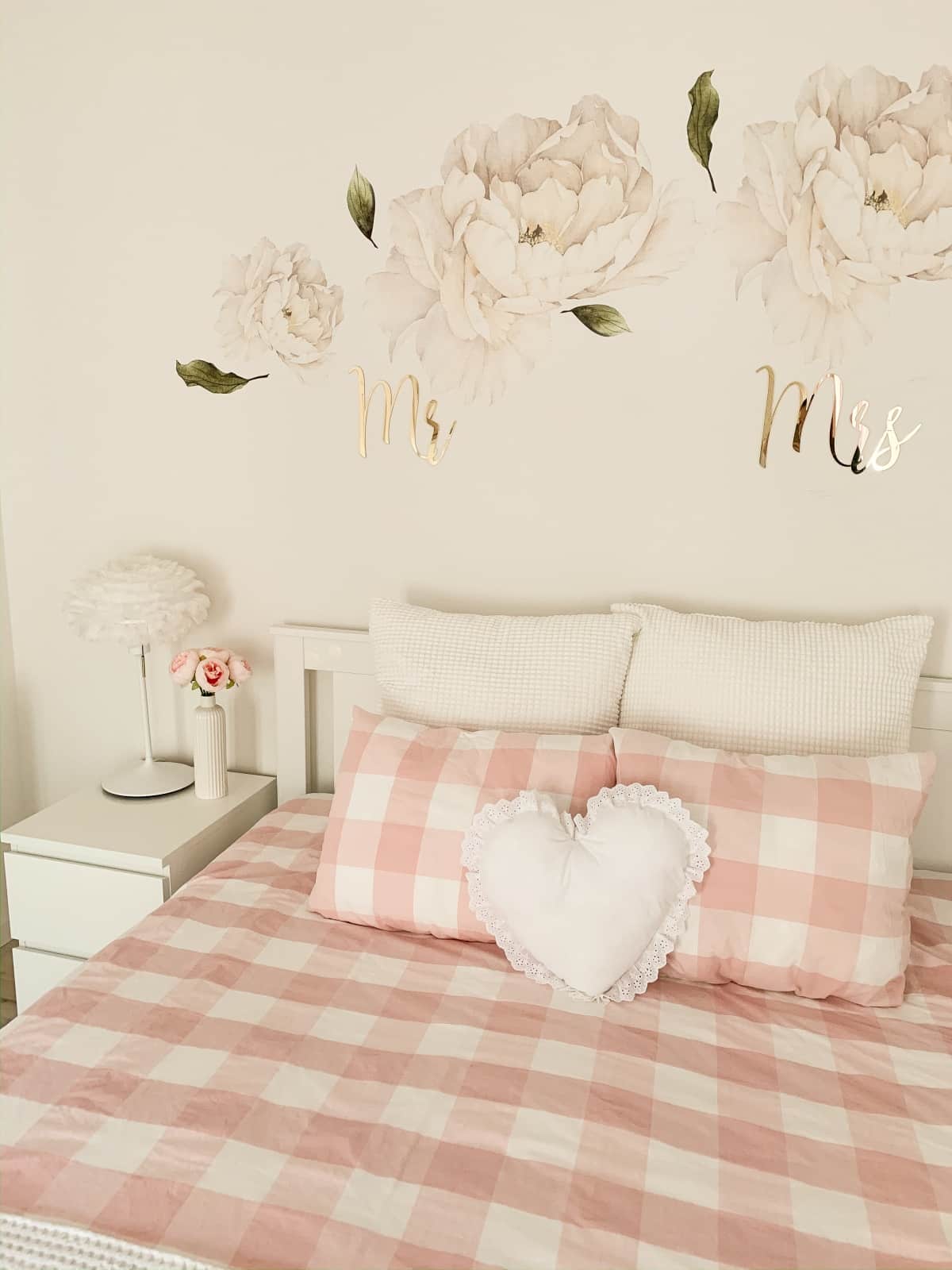 Bedroom with wall decals and pink-and-white plaid bedding