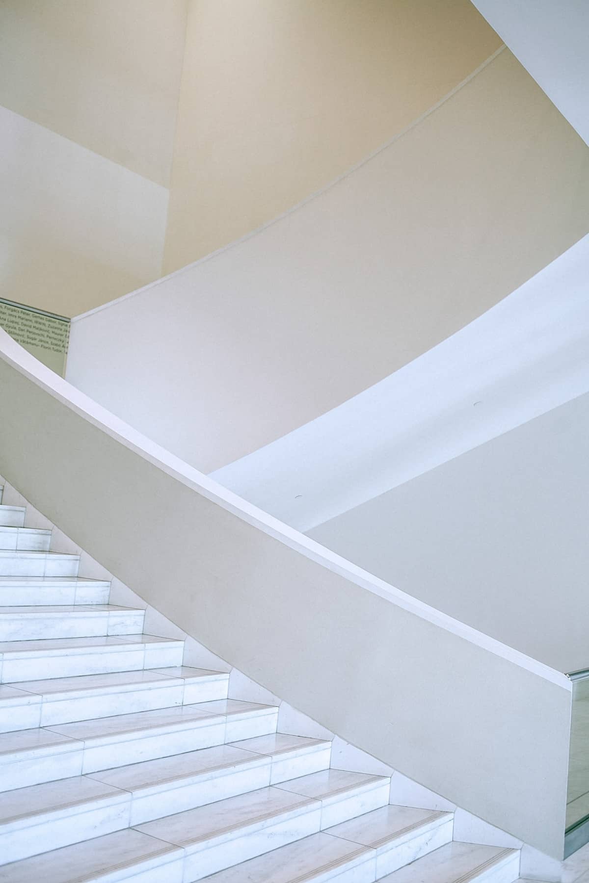 White staircase flight in spacious light hallway