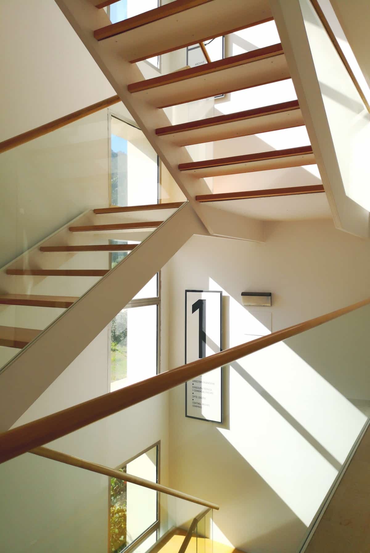 White staircase with wooden steps and glass panelling