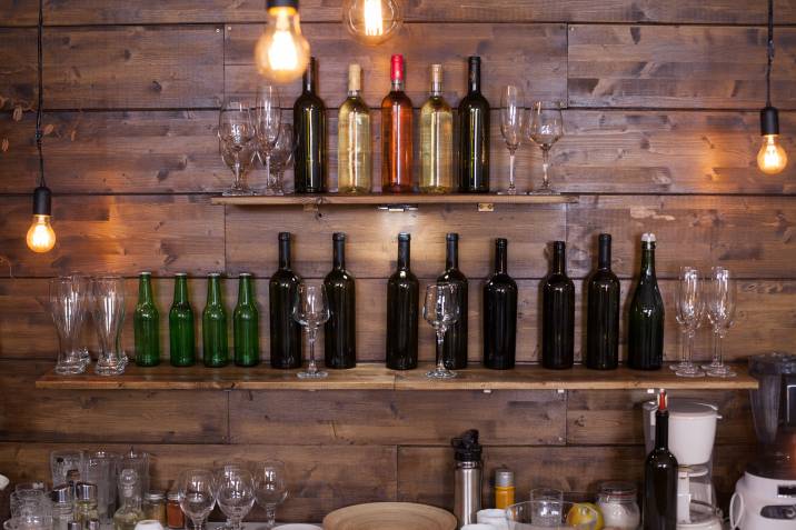 rustic wine shelf with bottles and wine glasses