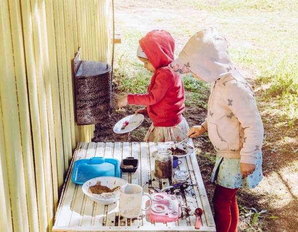 girls playing in their outdoor mud kitchen