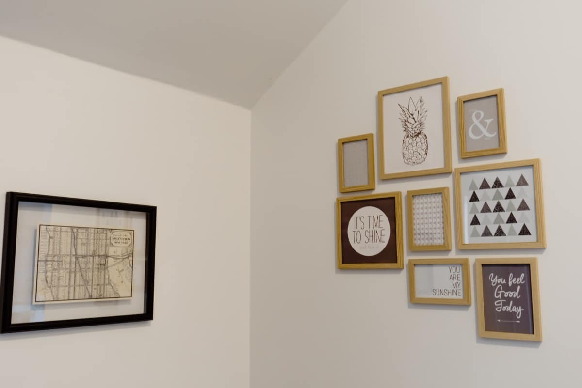 Wooden and black picture frames hanging on a white wall
