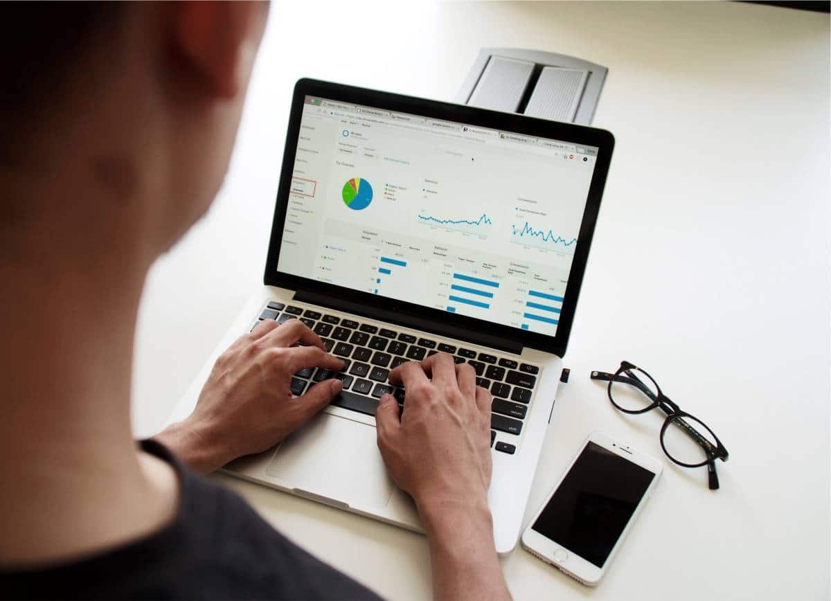 man looking at online charts on laptop