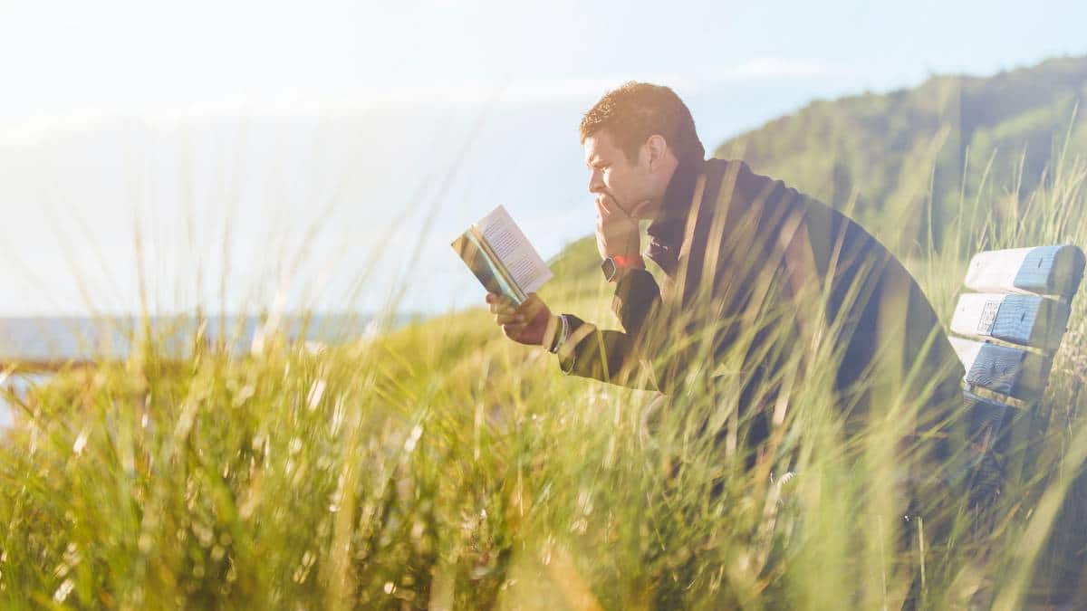 man reading a book outdoors