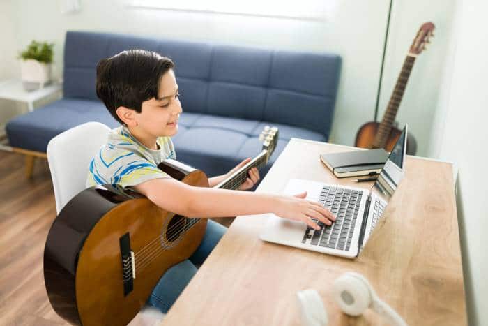 boy learning how to play the guitar online