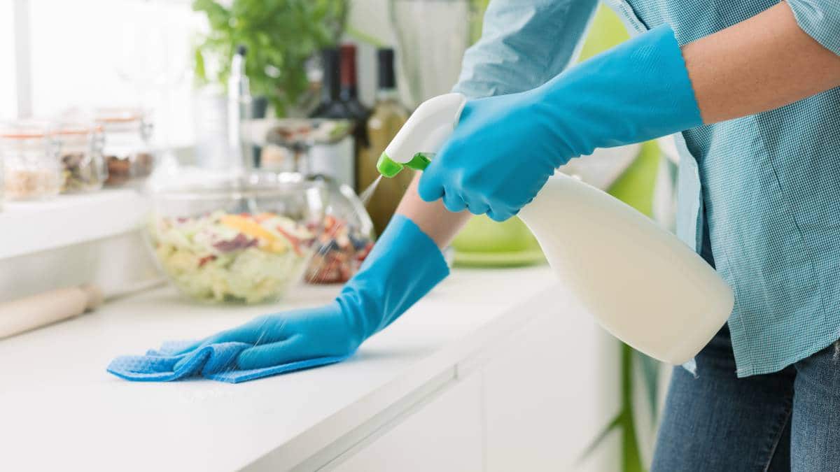 woman cleaning kitchen countertop