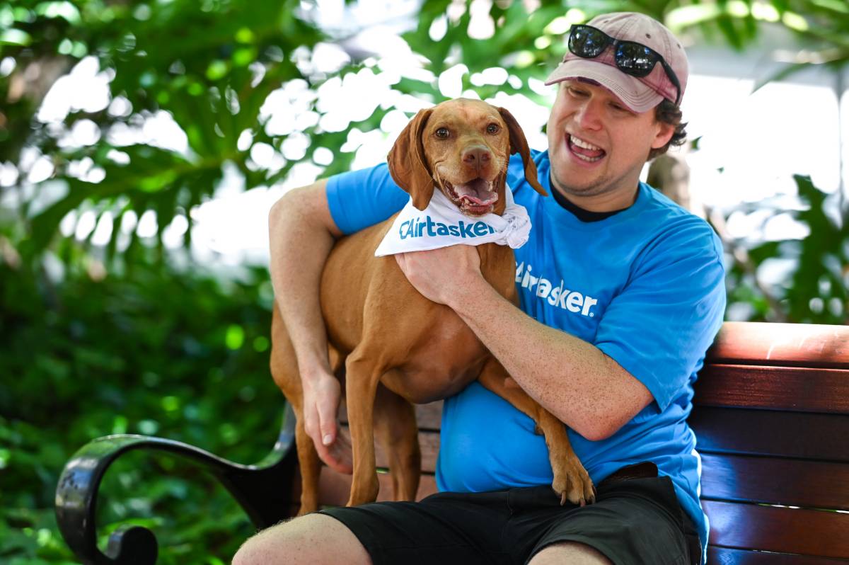 smiling dog and owner sitting in park bench