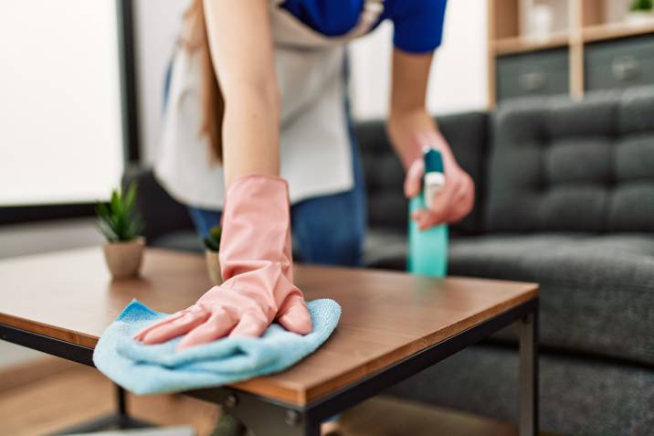 house cleaner cleaning table using rag and diffuser