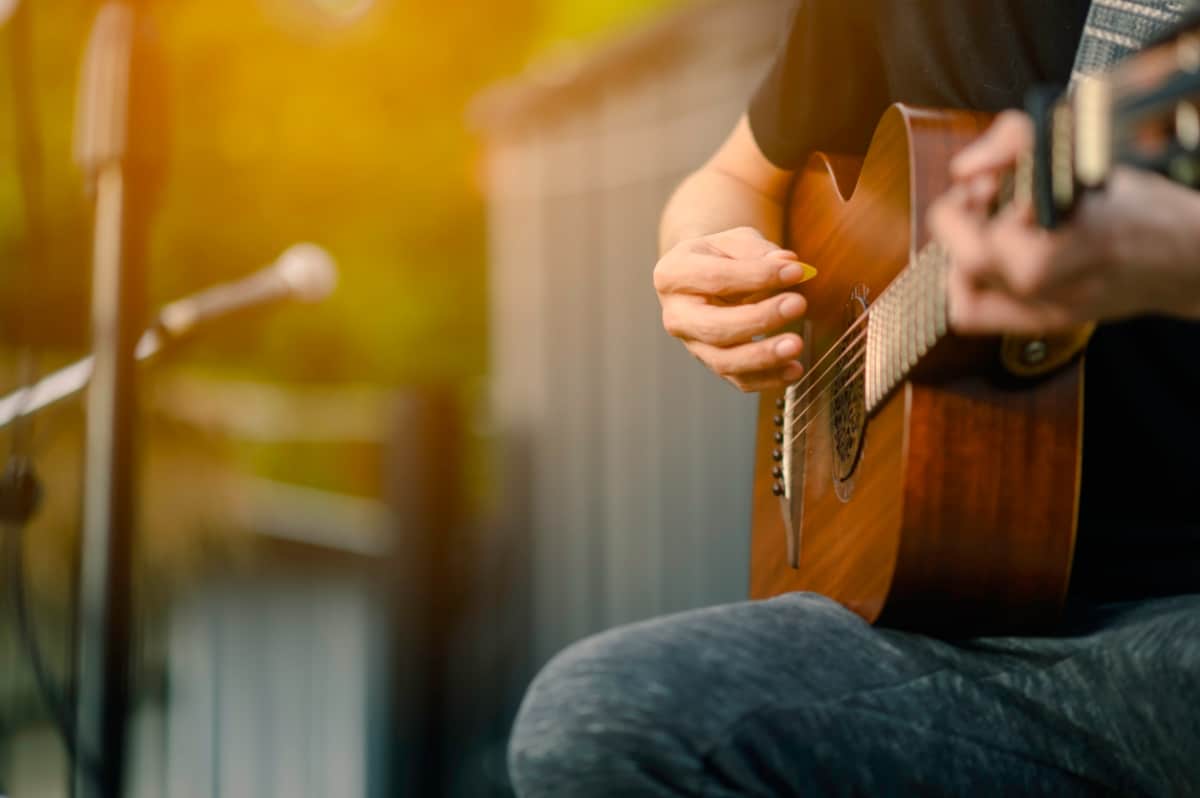 A close-up shot of a singer performing outdoors with his guitar.