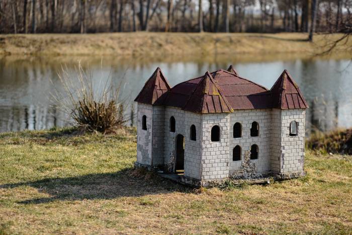 castle-shaped dog house on a river bank