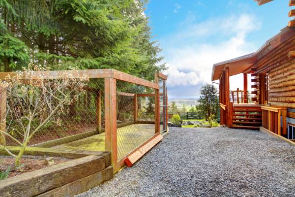 Log cabin with dogs fenced area behind the house