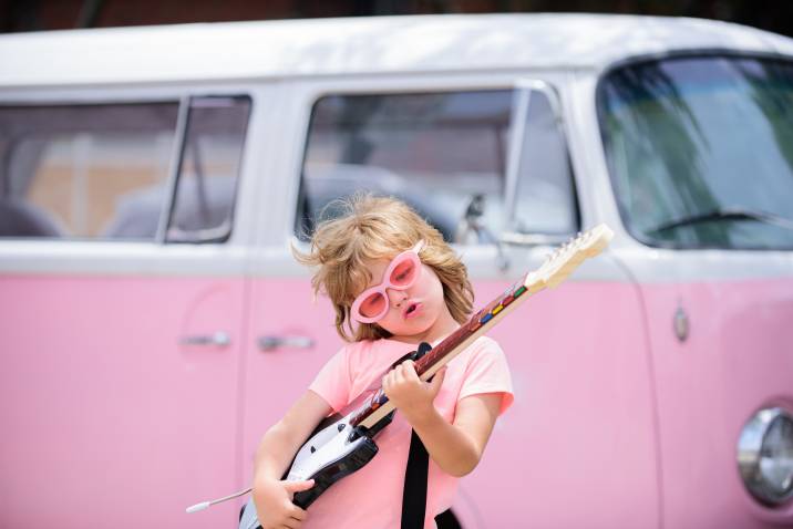 little girl playing with a guitar