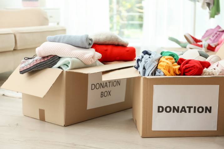 Donation boxes with clothes on floor indoors