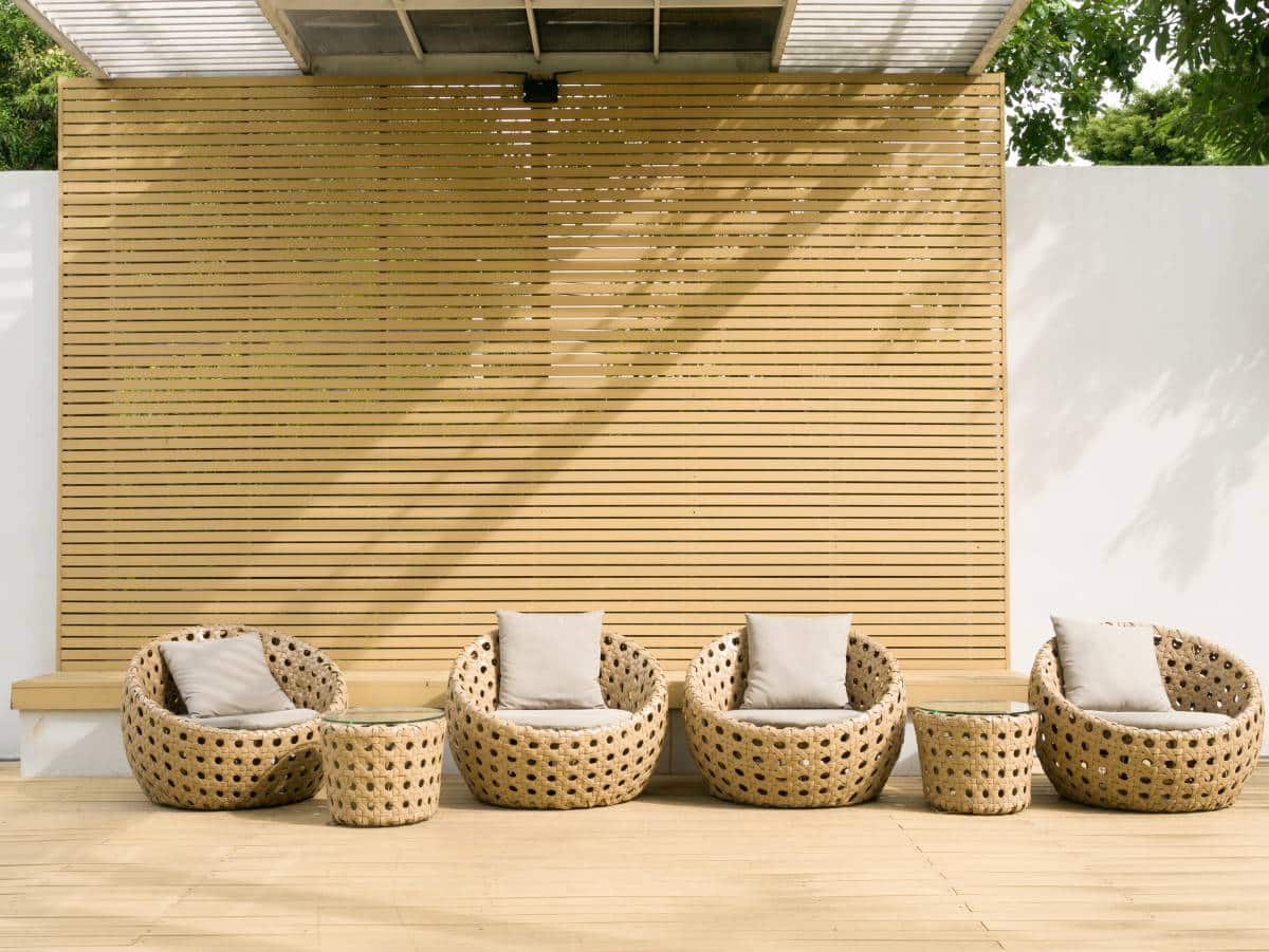 outdoor relaxing space with horizontal slat wall and rattan furniture