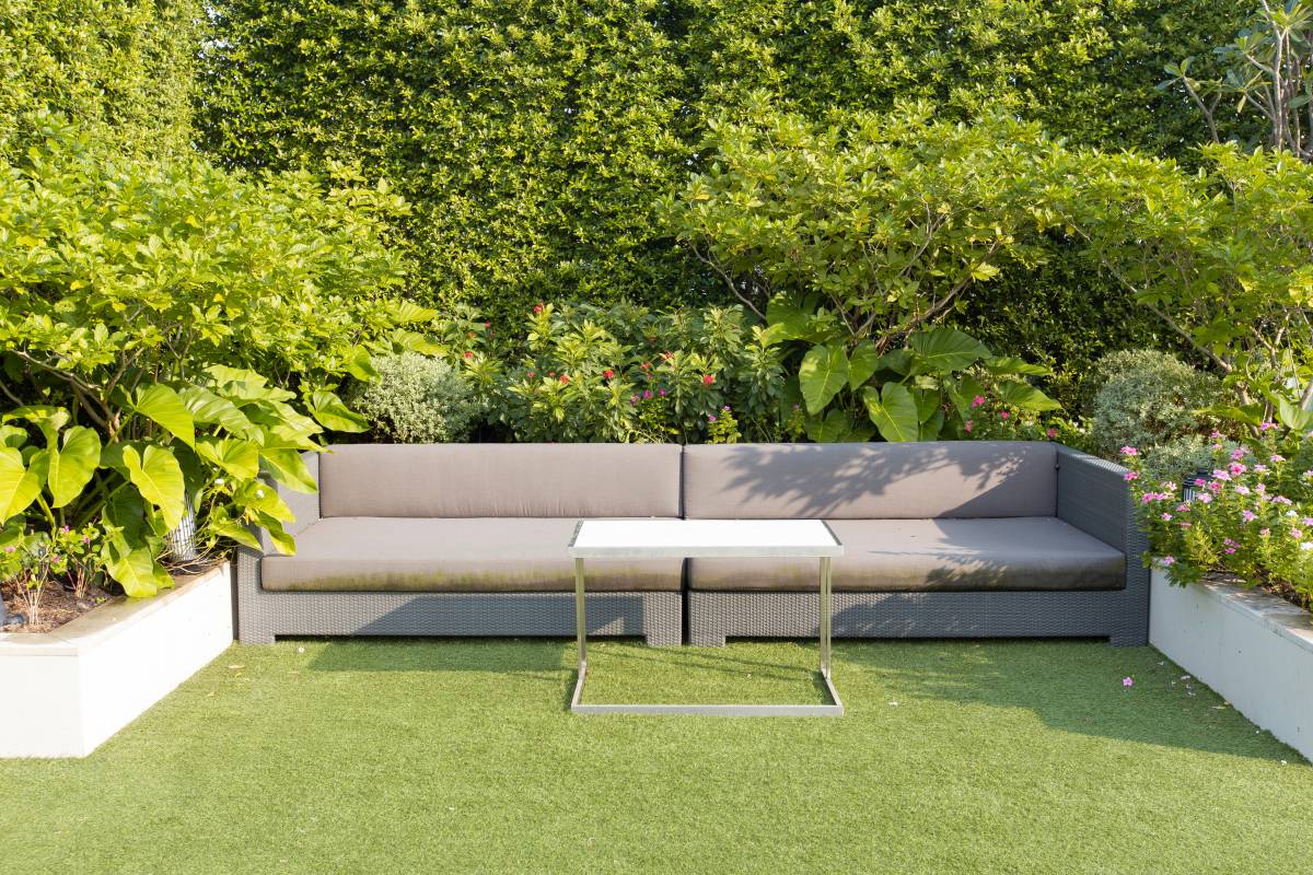 modern sofa nestled in a hedge privacy well in the garden 