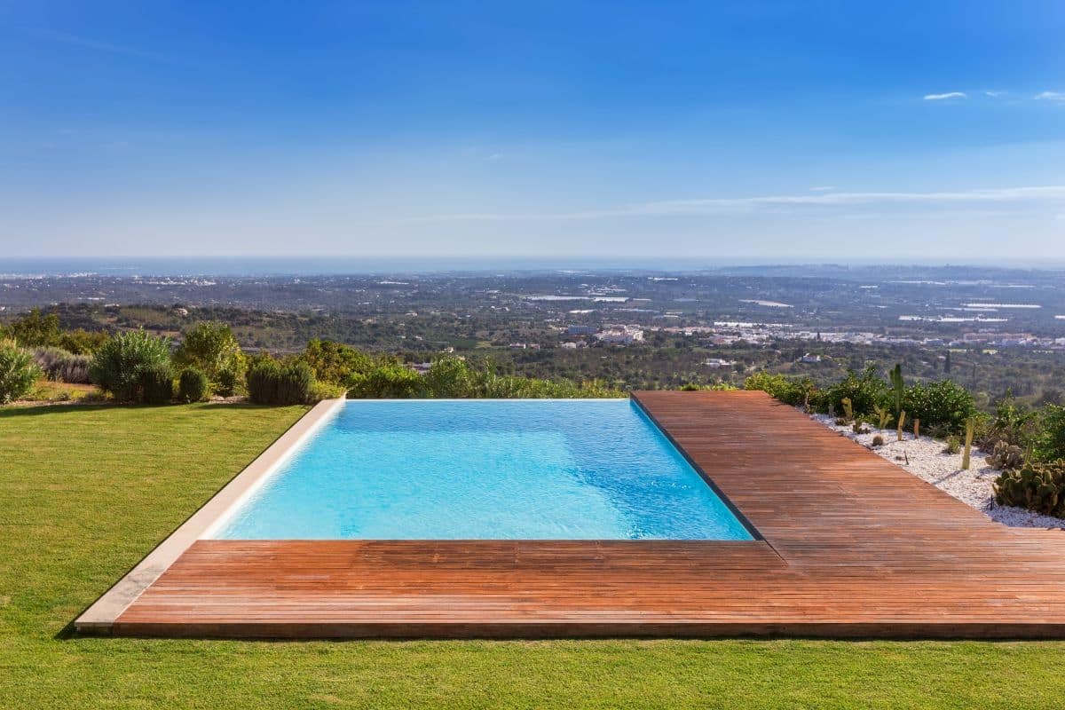 luxury pool with wooden deck, background of beautiful scenery 