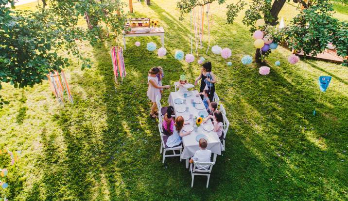 high angle view of small children sitting at a table outdoors in rented garden venue