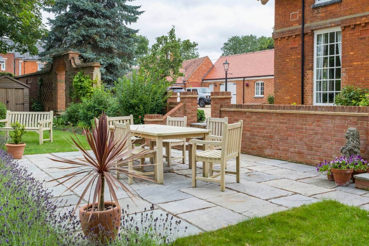 spacious back garden, wooden table and chairs on patio terrace