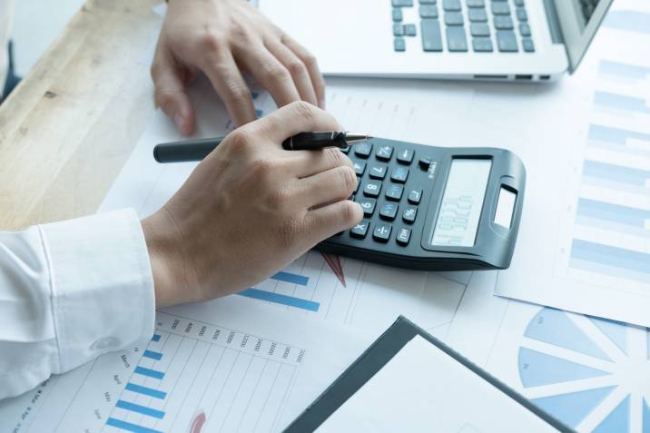 freelance accountant, bookkeeper working with calculator to set his service rates