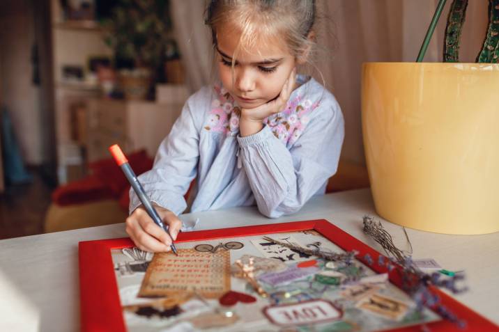 a little girl making her travel vision board