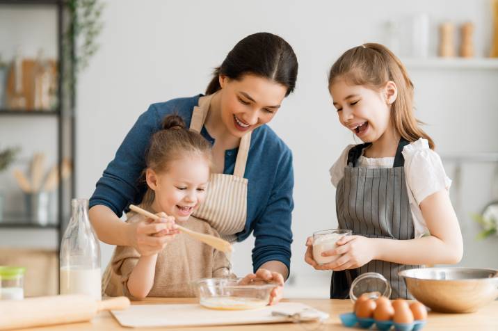 a mother with her daughters baking at home