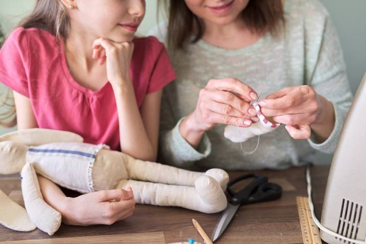 a mother and daughter sewing together